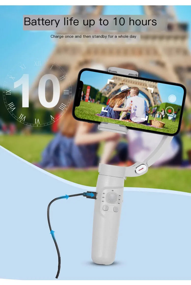 Handheld stabilizer with phone mount in front of the Eiffel Tower, displaying a phone screen with a couple on a grassy field.