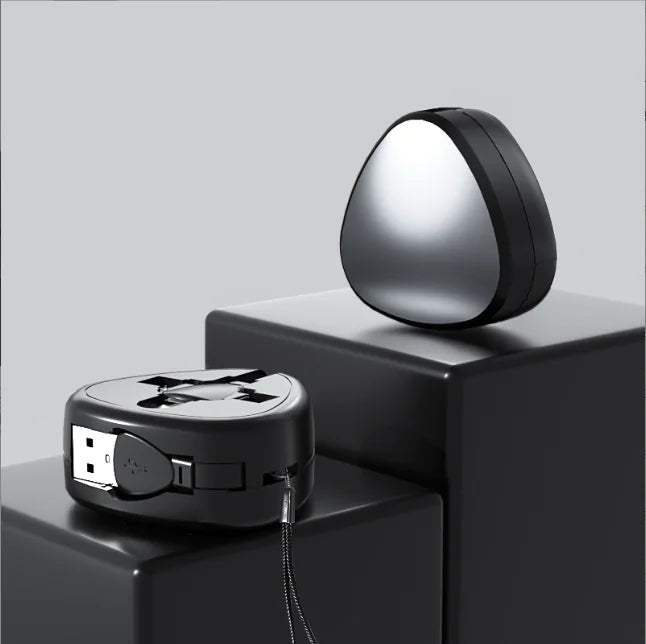Two metallic devices on a black surface with a gray background