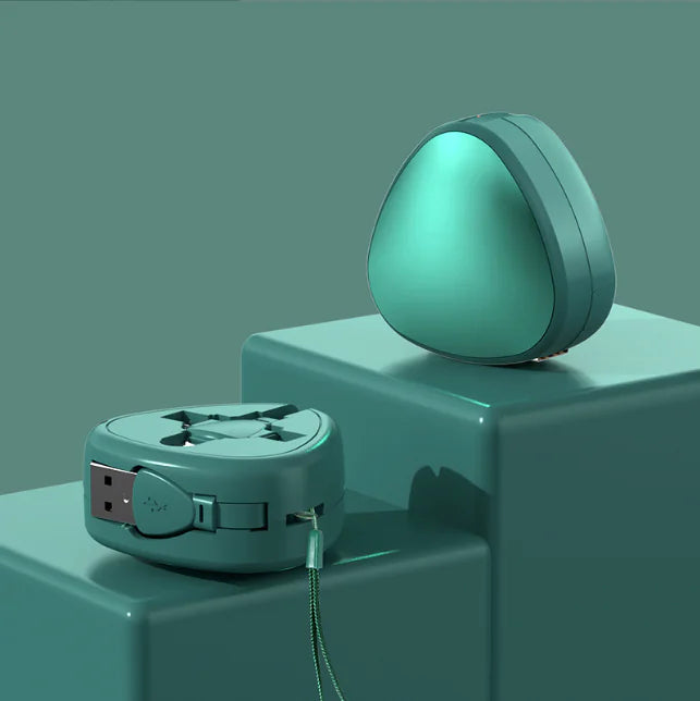 Teal travel adapter and USB cable on a teal surface with a gradient background