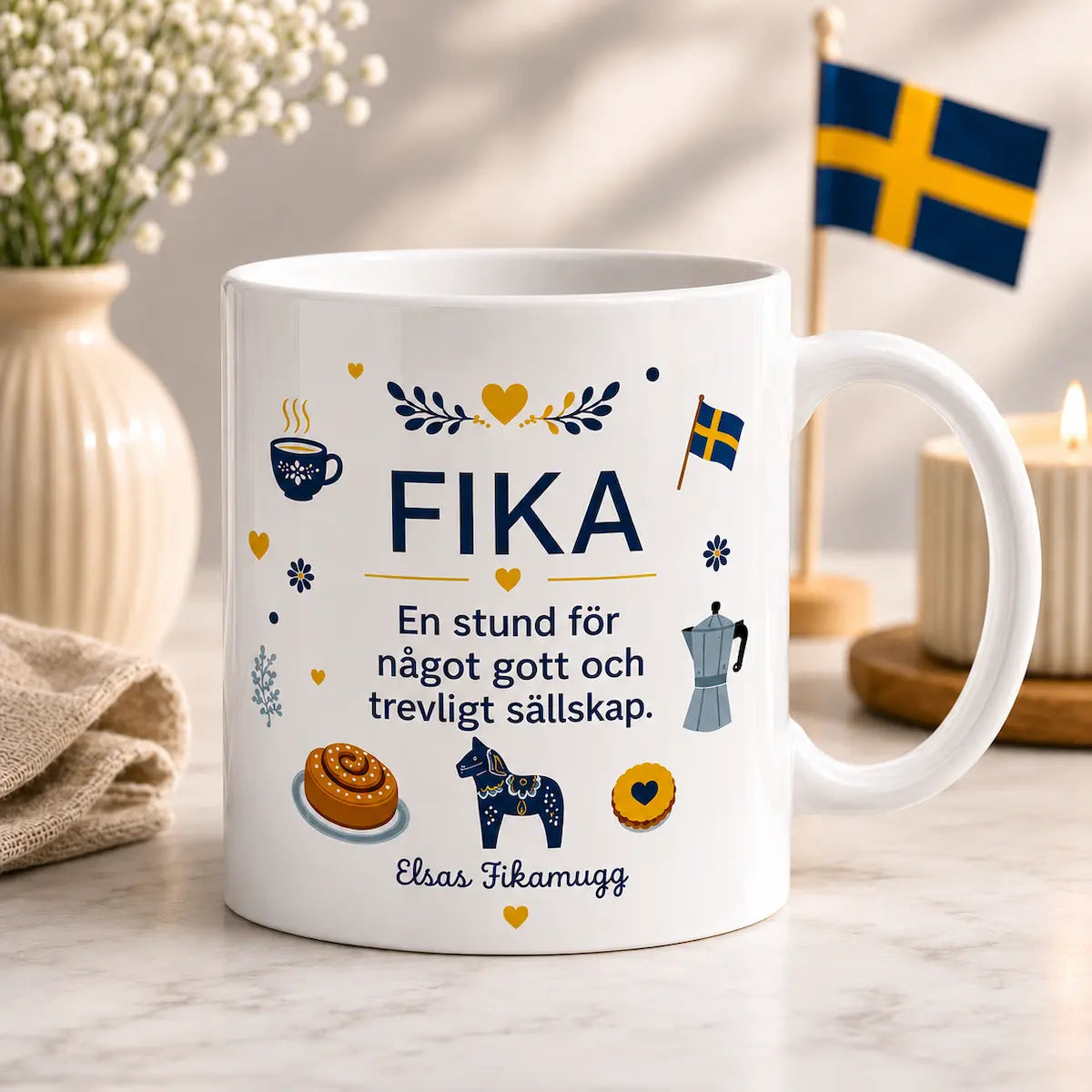 White mug with 'FIKA' text and Swedish-themed illustrations on a table with decorative items.