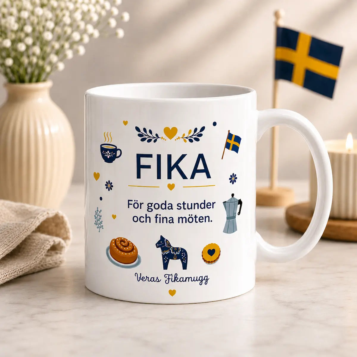 White mug with 'FIKA' text and Swedish design elements on a table with decor items.